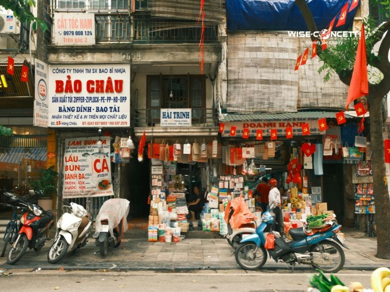 Hanoi Old Quarter storefronts with Vietnamese signage and national flags lining the street